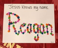 a sign that says jesus knows my name, made out of colorful beads and paper