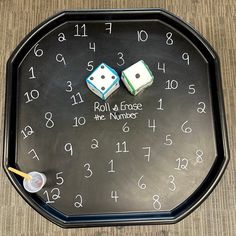 a black clock with two dices and numbers on it