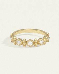 a yellow gold ring with five diamonds