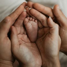 a person holding a baby's foot in their hands