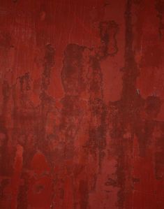 a red wall with peeling paint on it