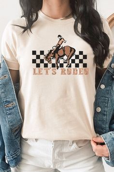 Get ready to hit the rodeo in style with our Let's Rodeo Checkered Horse and Cowboy Graphic Tee! White and Cream tees are 100% cotton, Ash tees are 99/1 cotton/poly. Perfect for any rodeo event or casual outing, this tee is a great way to show off your love for western culture. Whether you pair it with jeans or shorts, this tee is sure to keep you feeling comfortable and fashionable. Order now and saddle up for some rodeo fun! By Kissed Apparel.Made In: USAFabric Contents: Most t-shirt colors ar Spring Letter Print T-shirt For Rodeo, White Crew Neck T-shirt For Rodeo, Rodeo Graphic Tee With Crew Neck, Rodeo Graphic Crew Neck T-shirt, Graphic Tee For Rodeo And Spring, Spring Graphic Tee For Rodeo, Spring Rodeo Graphic Tee, Casual Cotton T-shirt For Rodeo, White Short Sleeve T-shirt For Rodeo