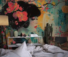 a woman with flowers in her hair is sitting on a bed next to a wall mural