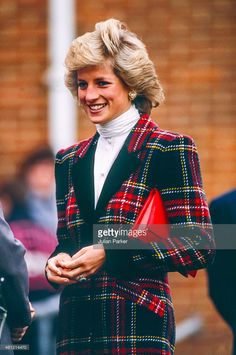 the princess of wales smiles as she wears a red and black plaid blazer jacket