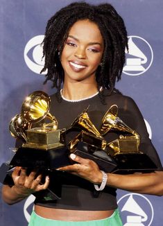 a woman holding two awards in her hands