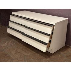 a white dresser sitting on top of a tiled floor