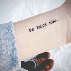 a woman's arm with the words be here now written in black ink on it