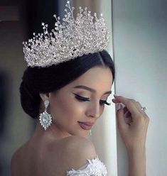 a beautiful woman wearing a tiara and earrings