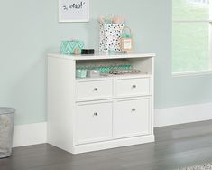 a white dresser in a room with blue walls