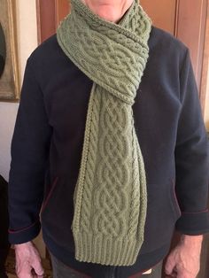 an older woman wearing a green knitted scarf