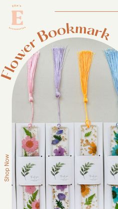 flower bookmarks with different colors and designs hanging from the side of a wall