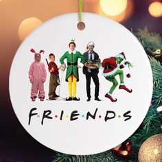 an ornament hanging from a christmas tree with three people dressed up as elfs