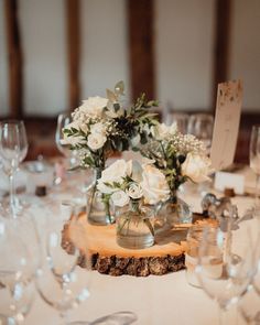 the table is set with white flowers and place cards