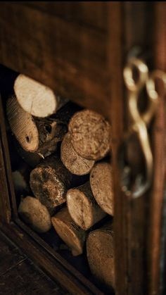 a bunch of wood stacked up in a wooden box next to a metal door handle