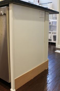 an empty kitchen island with a dishwasher in the middle and wood flooring