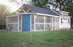 a small white and blue house in the grass