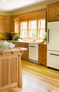 a large kitchen with wooden cabinets and white refrigerator freezer next to an island in the middle