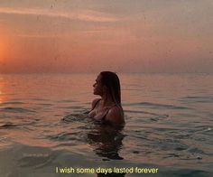 a woman is sitting in the water at sunset with her head above the water's surface