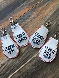 four baseball keychains with the words coach brain on them