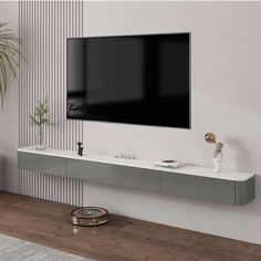 a flat screen tv mounted to the side of a white wall in a living room