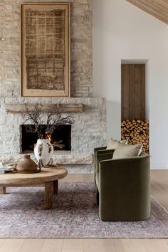 a living room filled with furniture and a fire place next to a wall mounted painting