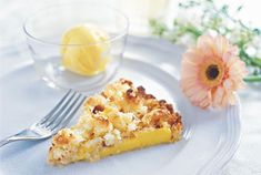 a piece of pie on a plate next to a glass bowl with lemon wedges