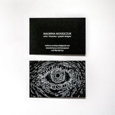 two black business cards with an eye on them