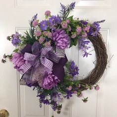 a wreath with purple flowers on the front door