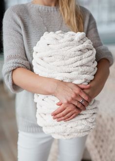 a woman holding a stack of white towels