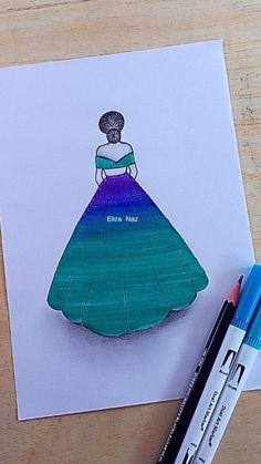 a drawing of a woman in a blue dress on a piece of paper with markers