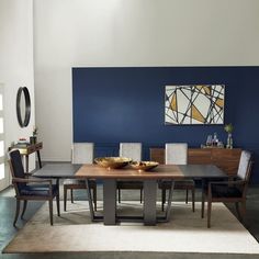 a modern dining room with blue walls and white carpeted flooring, along with an area rug on the floor