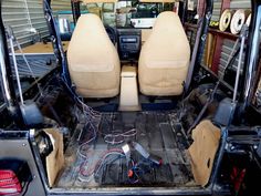 the inside of a vehicle with its doors open and wiring in place on the floor