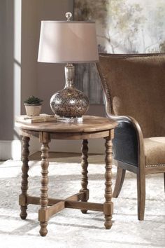 a table with a lamp on top of it next to a chair and a couch