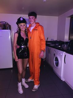 a man and woman dressed in costumes standing next to each other near a washing machine