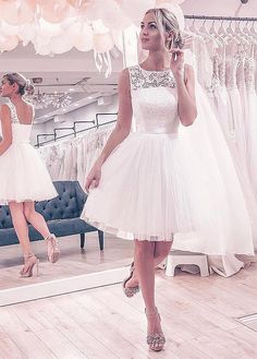 a woman standing in front of a mirror wearing a white dress