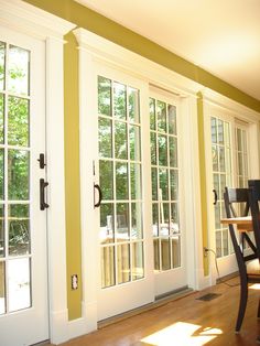 a dining room with french doors and chairs