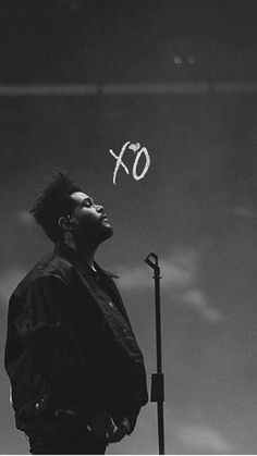 a man standing in front of a microphone with the word xo written above him