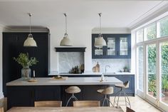 a kitchen with an island and bar stools in front of the countertop area