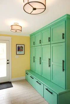 an empty room with green cabinets and yellow walls