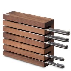 four knives are stacked on top of each other in the same holder, with one knife sticking out of it's side