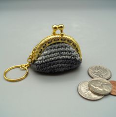 a coin purse sitting on top of a table next to a keychain and some coins