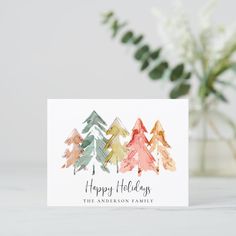 a card with watercolor trees on it and the words happy holidays written in green ink