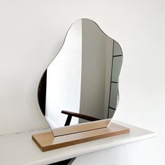 a mirror sitting on top of a white shelf