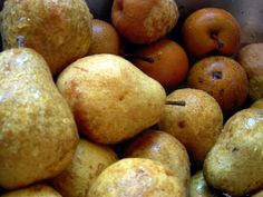 a pile of pears and oranges sitting next to each other