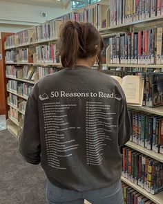 a woman standing in front of a bookshelf filled with lots of book's