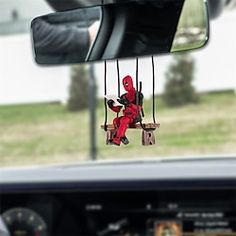 a car mirror with a deadpool hanging from it's side