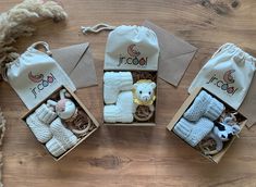 three small boxes filled with baby items on top of a wooden floor