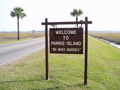 a welcome to paris island sign in the grass