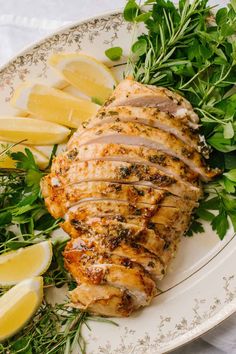 sliced chicken with herbs and lemons on a plate