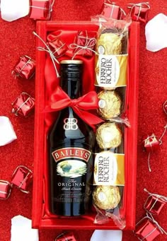 two bottles of bailey's and chocolates in a red gift box with bows